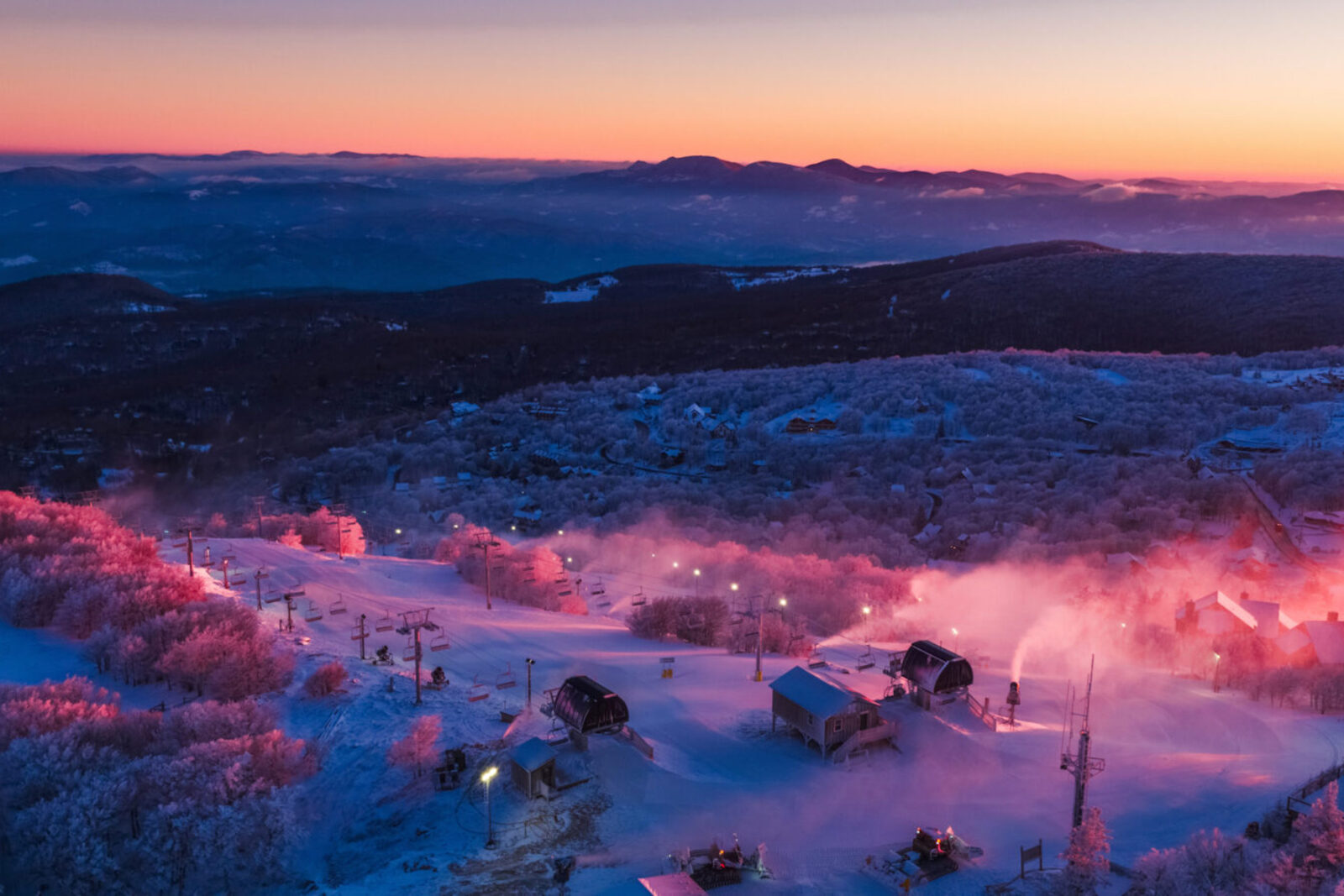 A sun sets over a ski resorts