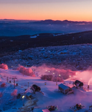 A sun sets over a ski resorts