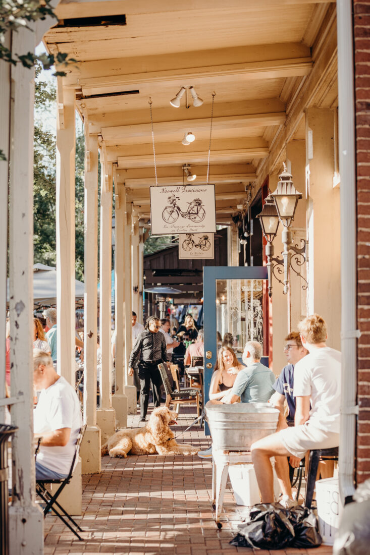 People dine outside on a brick-lined sidewalk