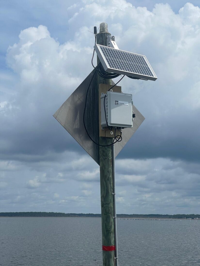 A technical device is mounted on a wood station in the water