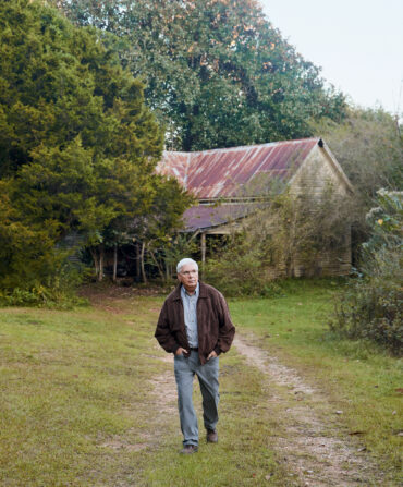 A man walks on a worn dirt path outdoors