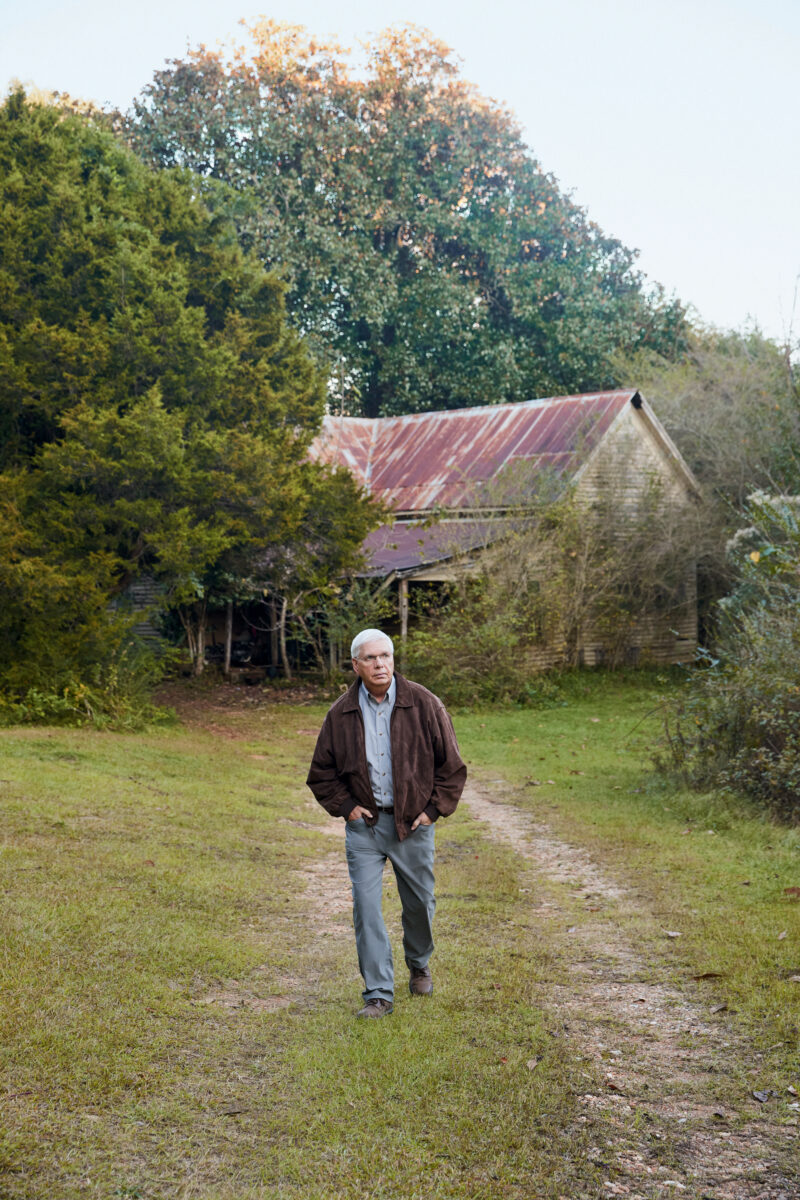 A man walks on a worn dirt path outdoors