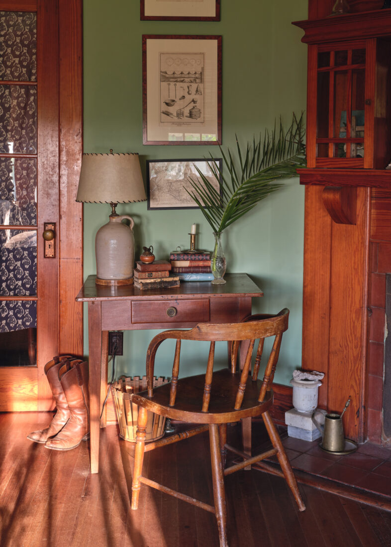 An antique wood chair in a green-painted writing nook