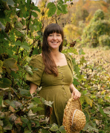 A woman stands in a patch of kudzu