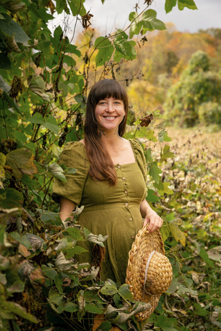 A woman stands in a patch of kudzu