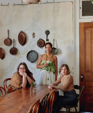 Three women sit at a dinner table