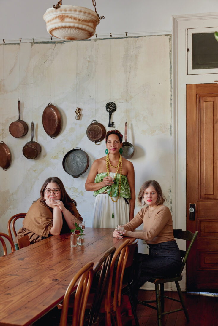 Three women sit at a dinner table