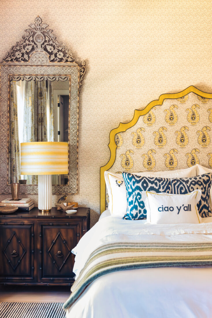 A hotel room with an ornate headboard on a bed