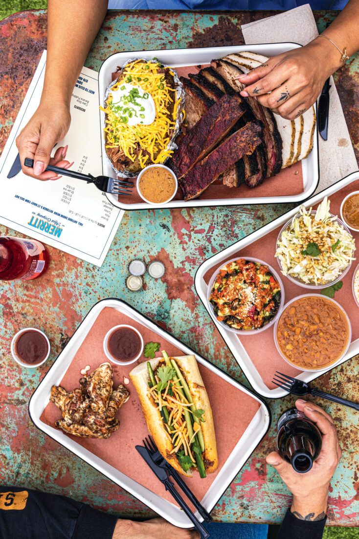 A spread of bbq on metal trays on a table