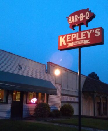 The exterior of a BBQ joint with a pig on a sign