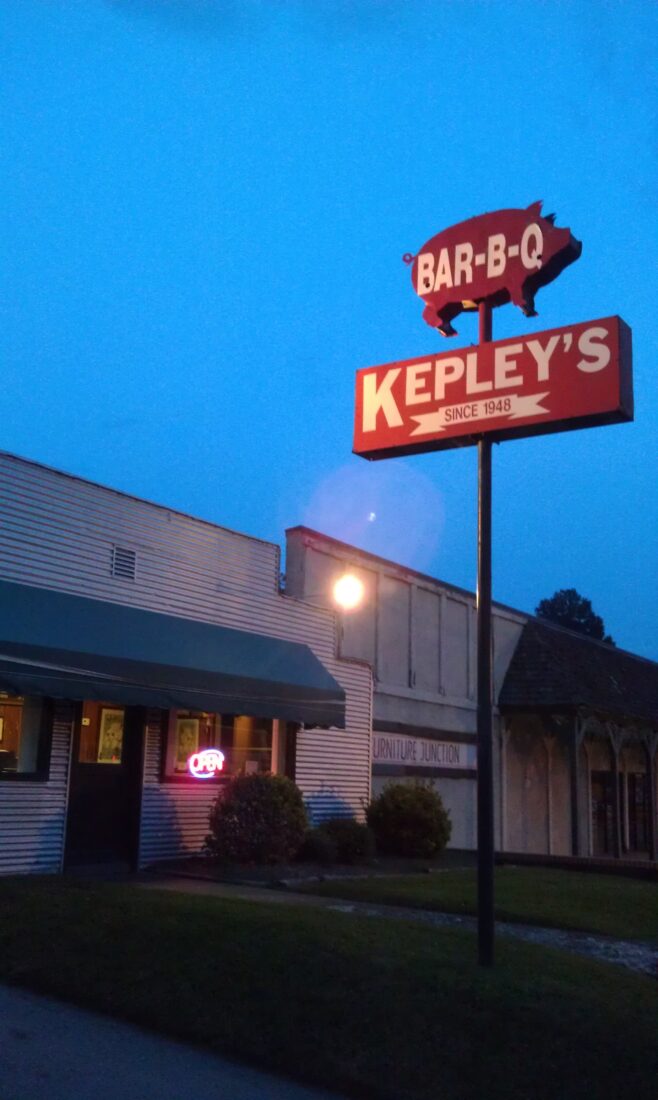 The exterior of a BBQ joint with a pig on a sign