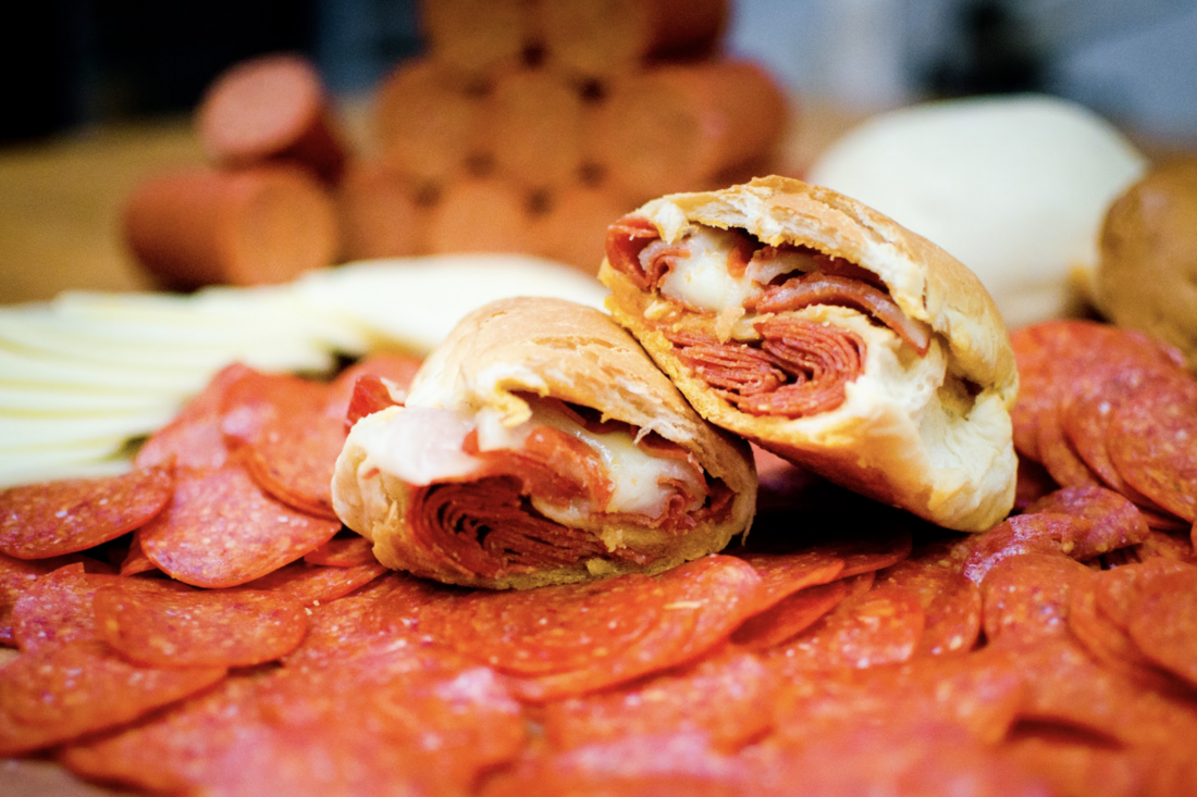 A pepperoni roll on a bed of pepperonis