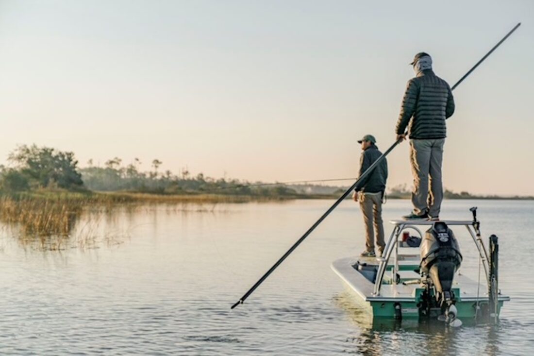 People fish while standing on a boat