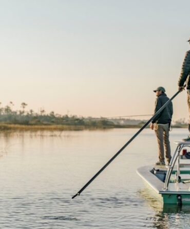 People fish while standing on a boat