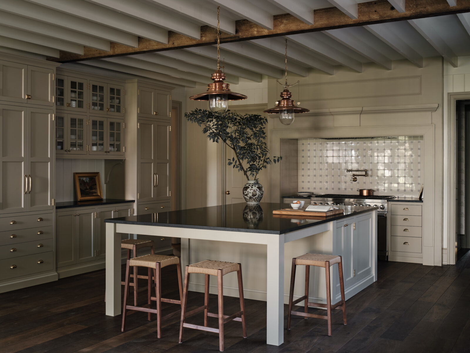 The kitchen features a large island and a range inspired by early American hearths, surrounded by blue and white delft tiles.