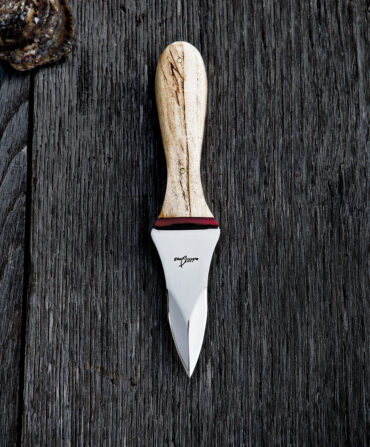 An oyster knife on a wooden background