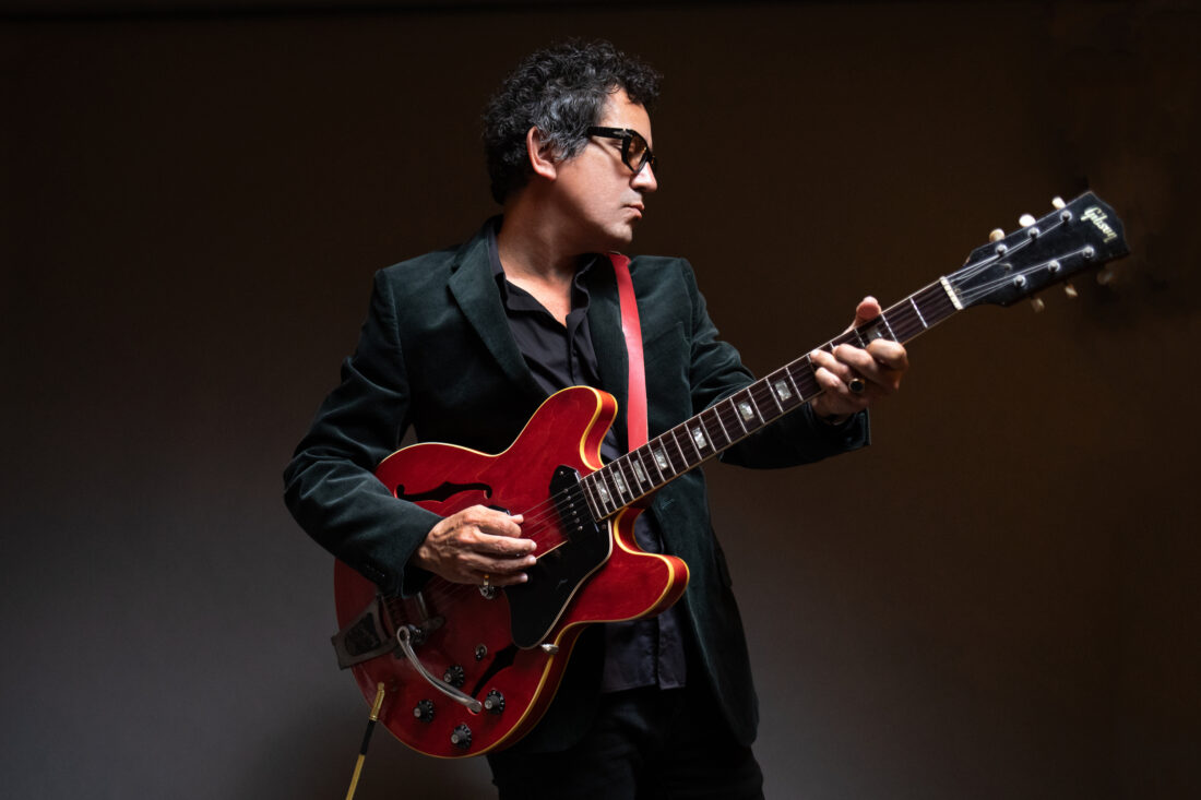 A portrait of a man holding a guitar