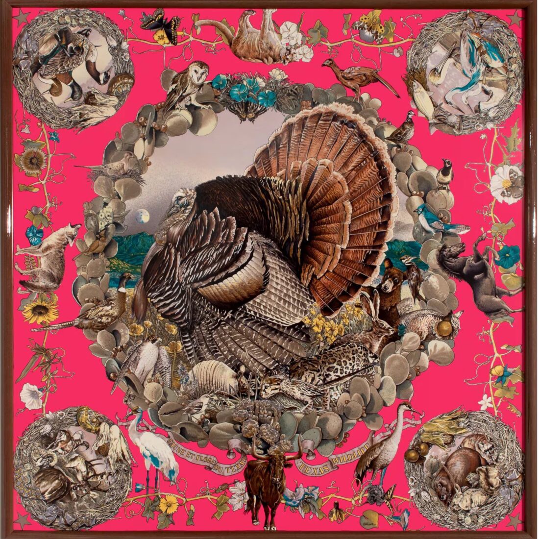A pink scarf with the flora and fauna of Texas and a turkey in the center