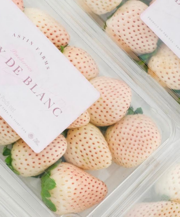 Containers of strawberries that are light pink and white