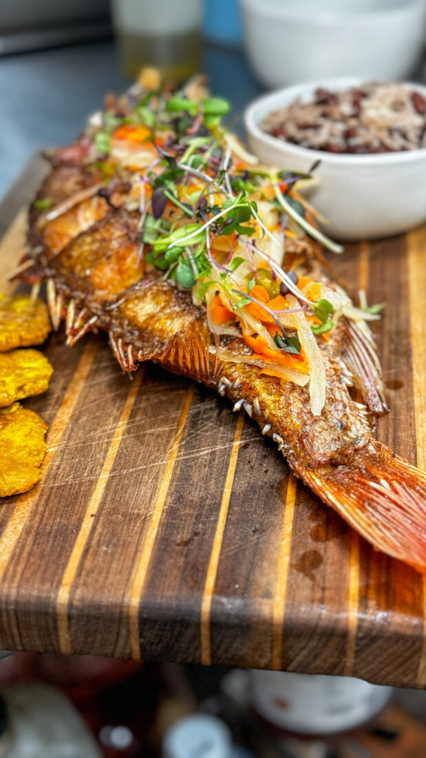 A cooked whole fish on a wood board