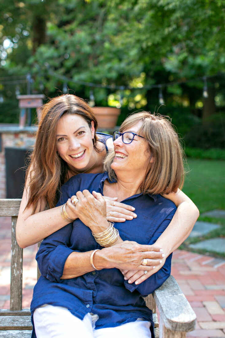 A portrait of two women hugging on a bench