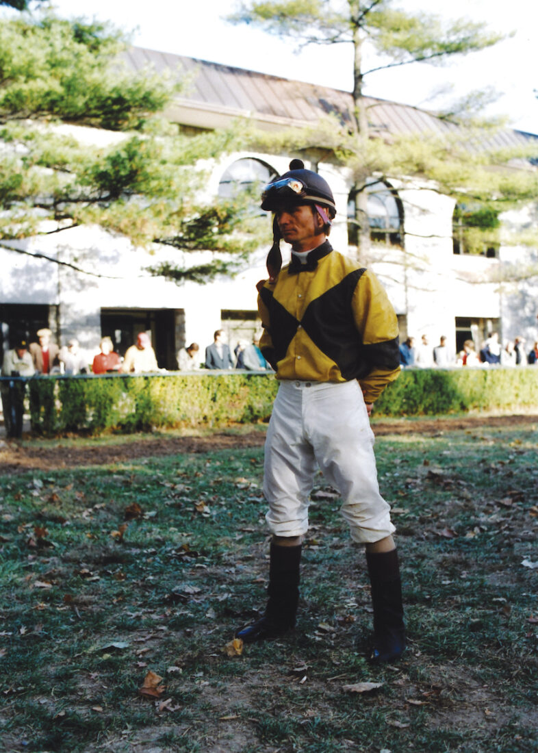 A jockey stands in a paddock
