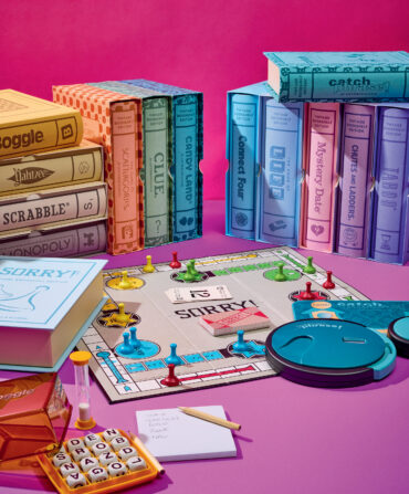 A spread of boardgames on a pink background