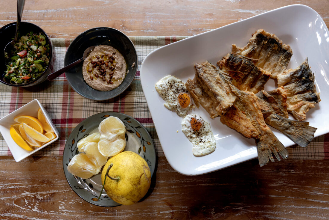 A spread of food on plates including fried trout