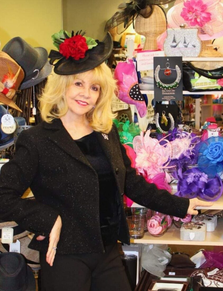 A woman standing in front of a display of hats