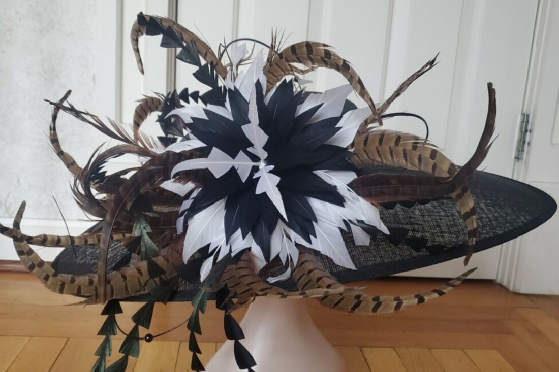 A black hat with black, brown and white feathers