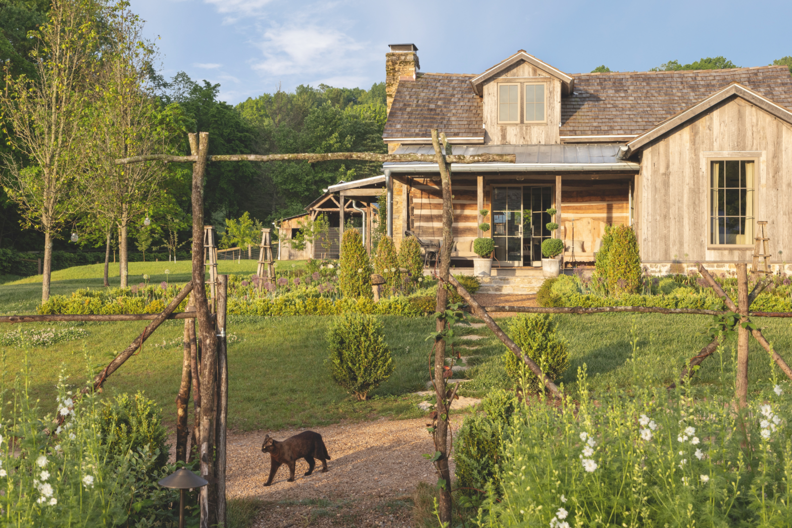 A cabin with wood fencing and a landscaped yard