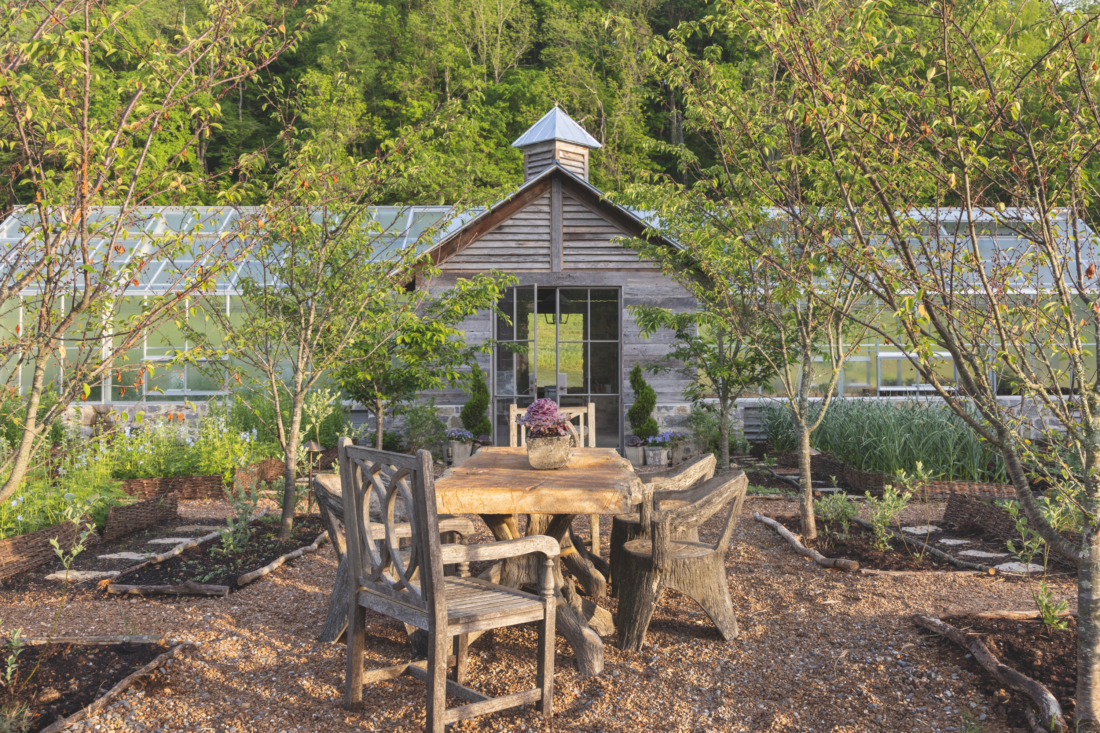 The exterior of two greenhouses connected by a central wood building