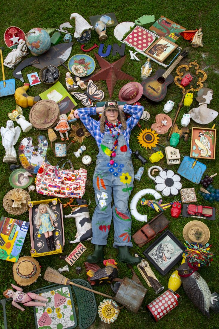 A woman lays surrounded by colorful objects