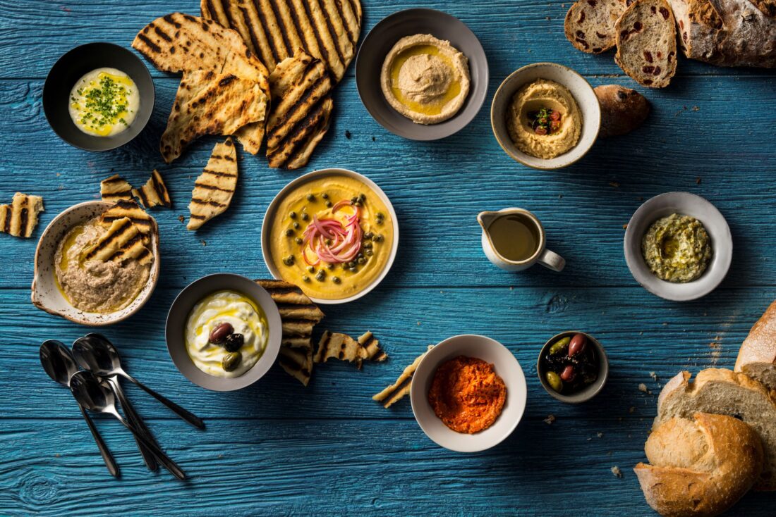 Bowls of spreads and pieces of bread