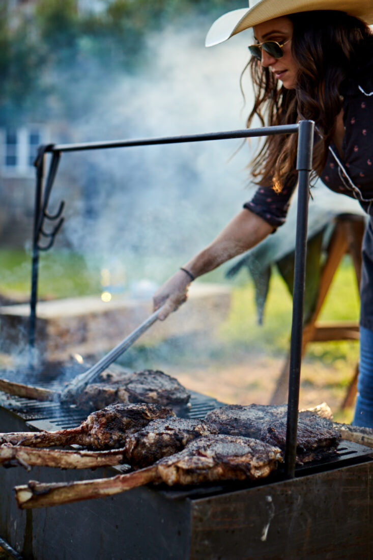 A woman grilling steaks
