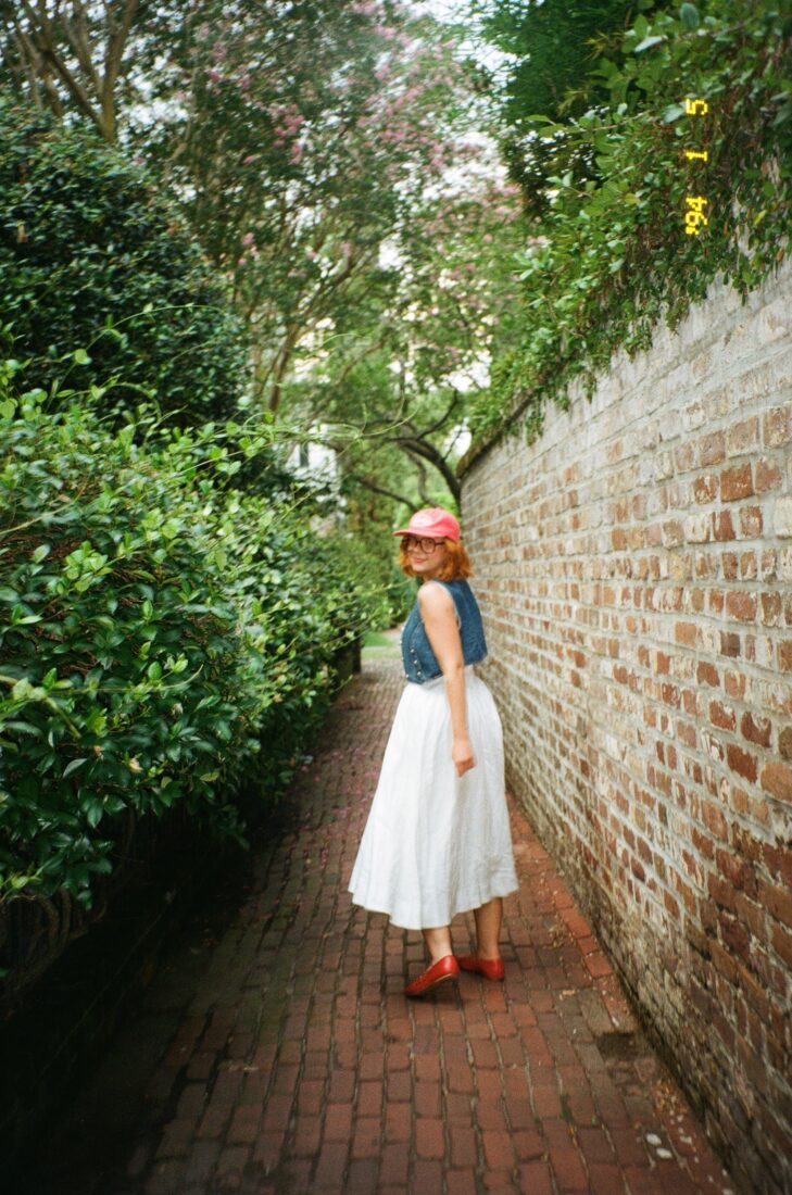 A woman walks through a brick alley