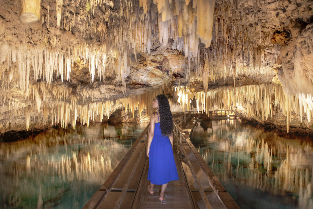 A woman walks down a cave system