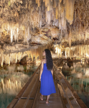 A woman walks down a cave system