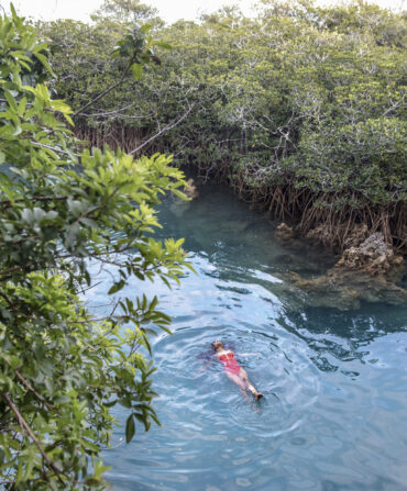 A woman swims in a blue natural pool