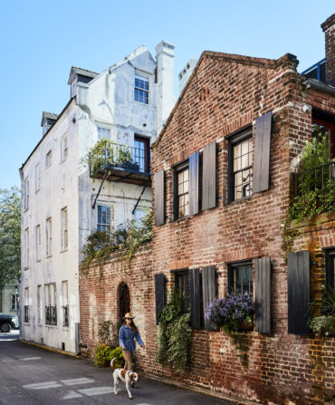A woman and dog walk down an alley