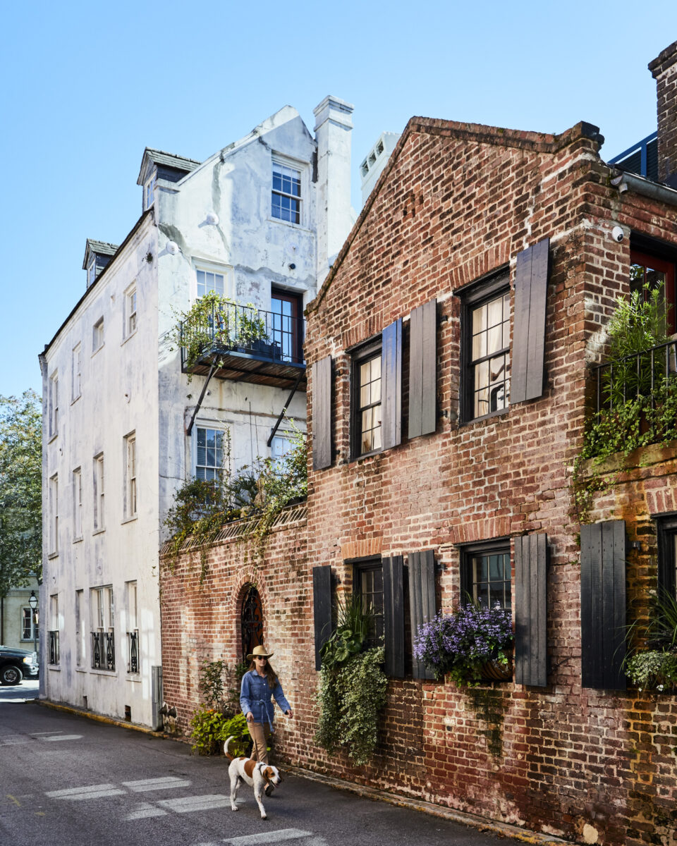 A woman and dog walk down an alley