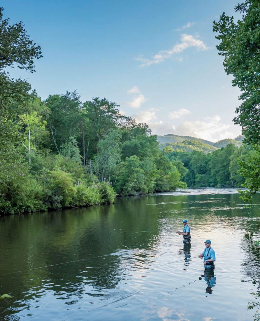 People fly fish in a river