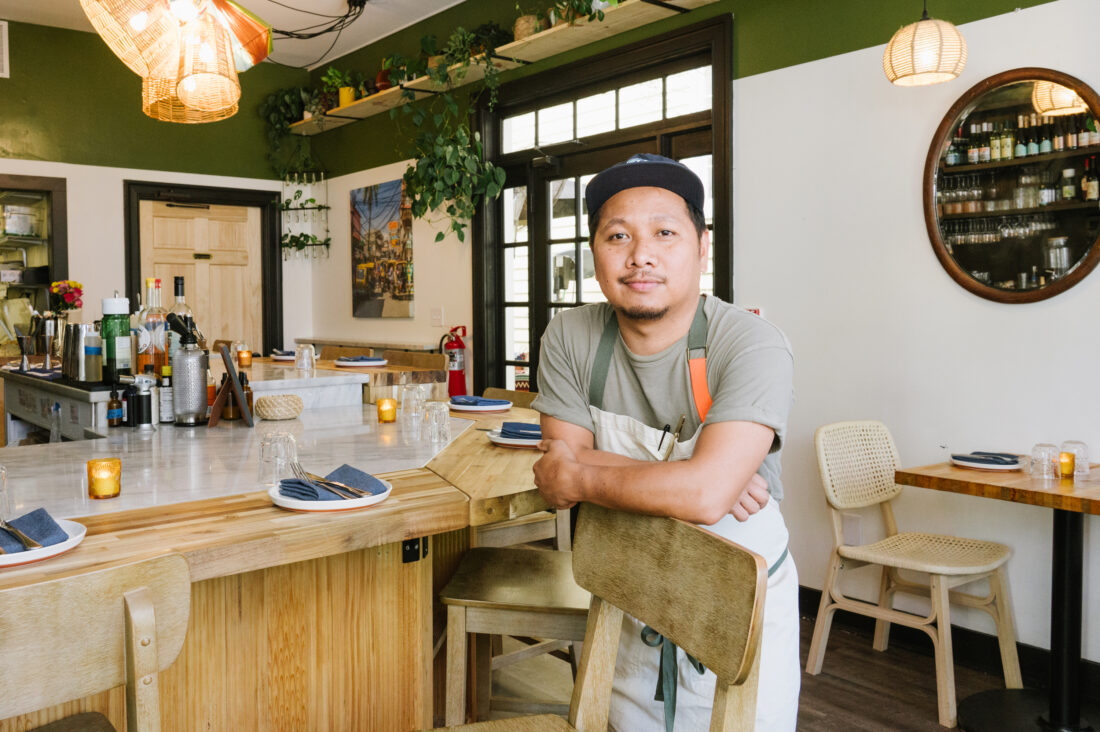 A chef stands in a dining room