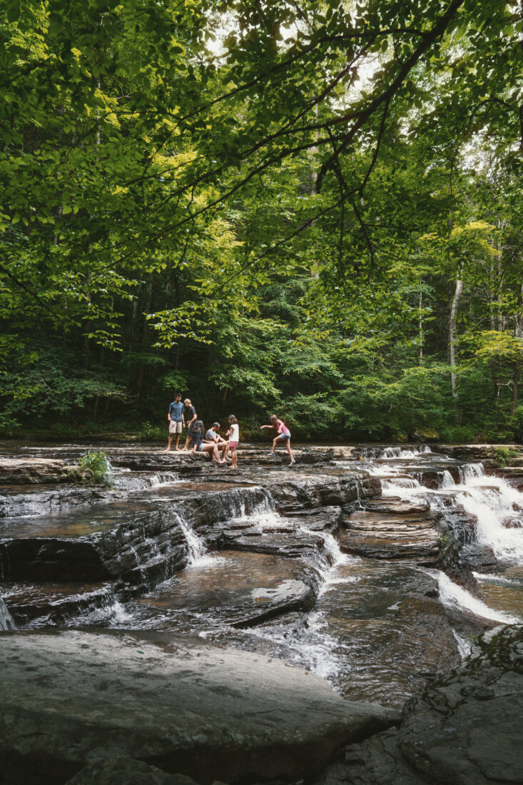 A family plays in water in a mountain landscape