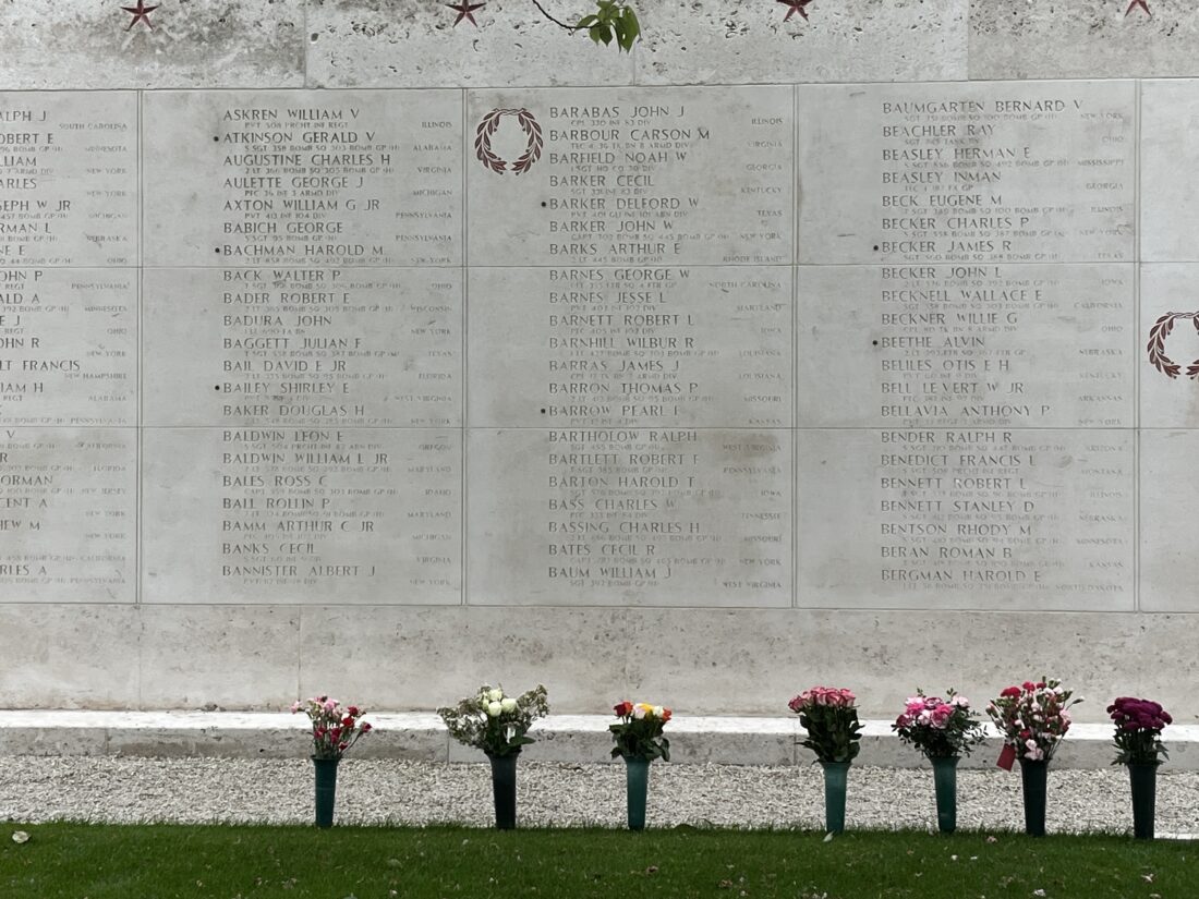 A memorial wall with flowers