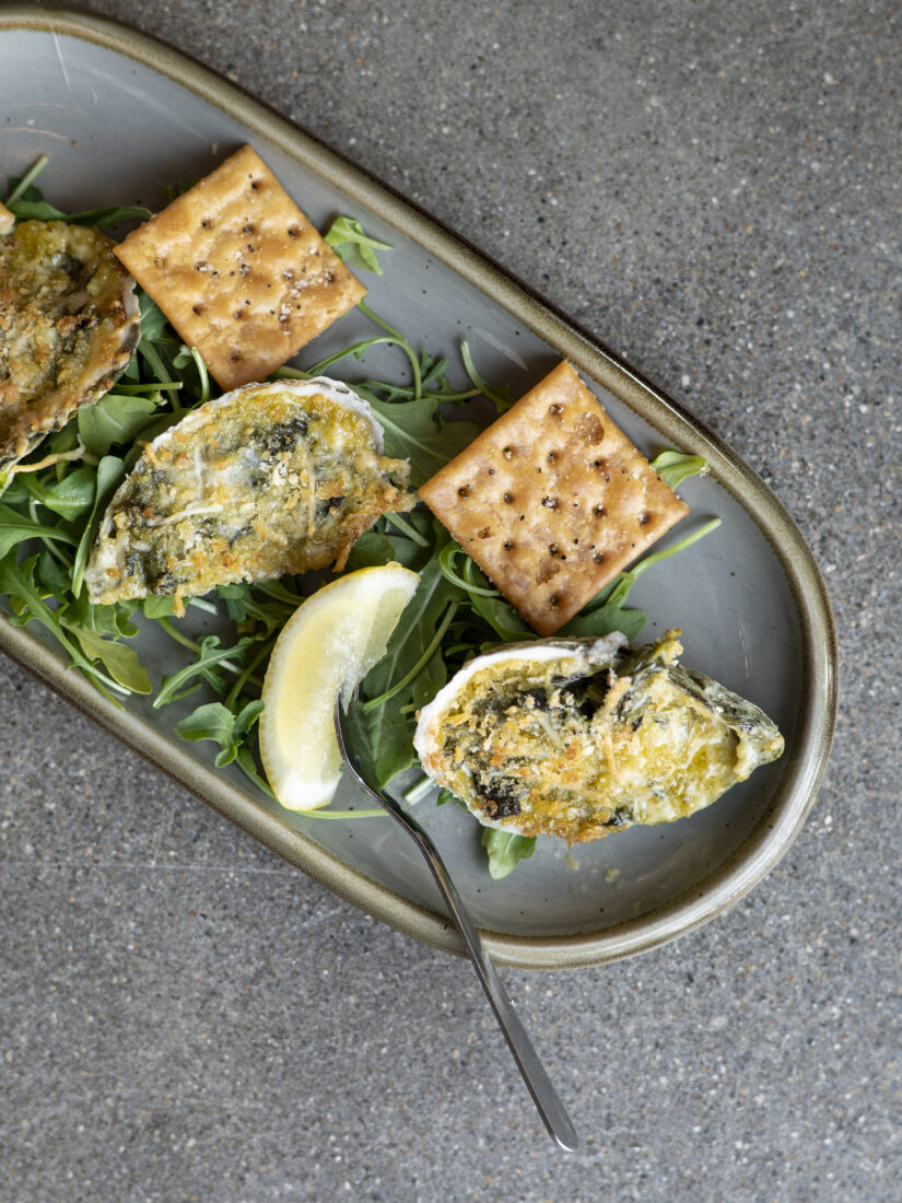 Oysters Rockefeller: oysters on the shell, Pinchy’s house Rockefeller mixture, spinach, shallots, white wine, parmesan, and garlic.