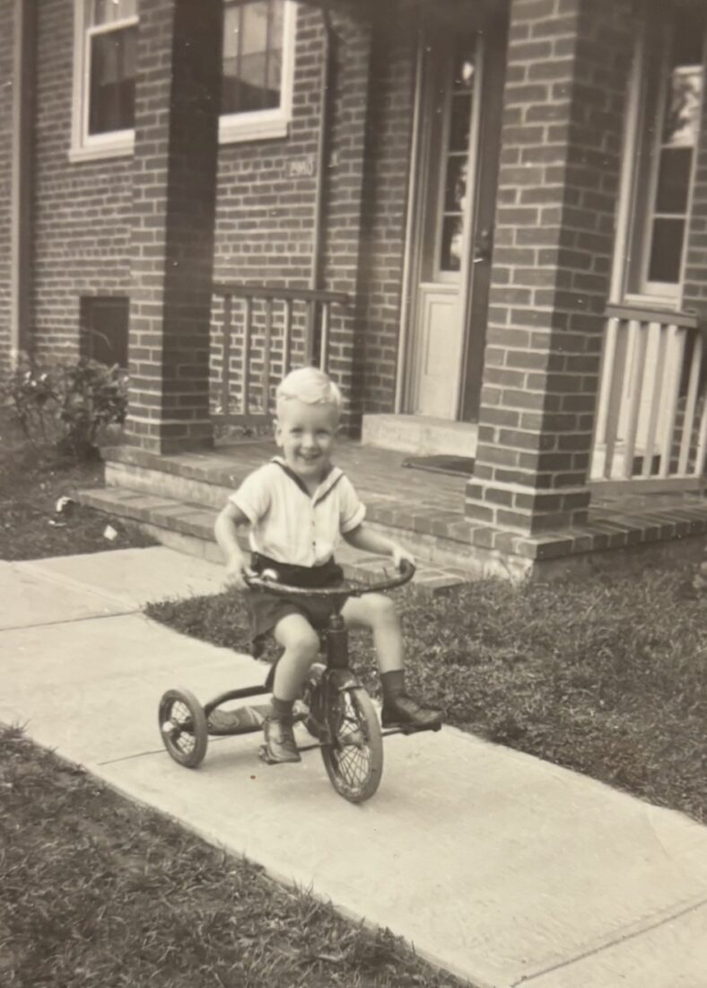 A vintage photo of a boy on a bike