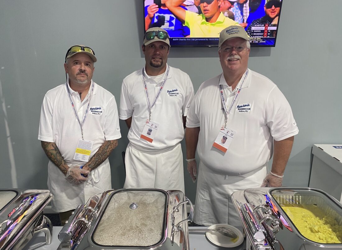 A group of men by trays of food