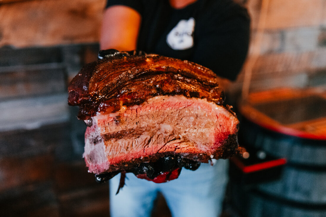 A person holds beef brisket