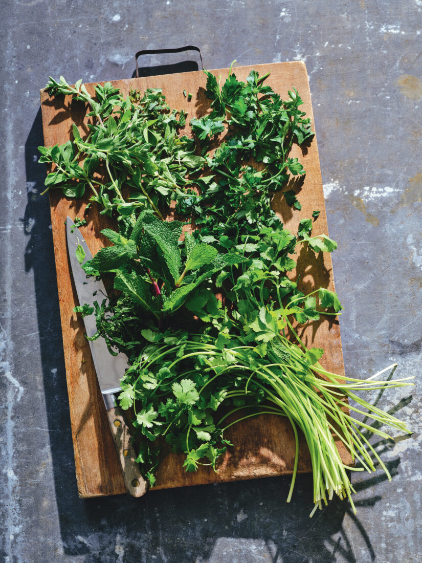 A bundle of fresh herbs on a cutting block